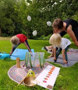 Kinder und Erwachsene machen Yoga im Park
